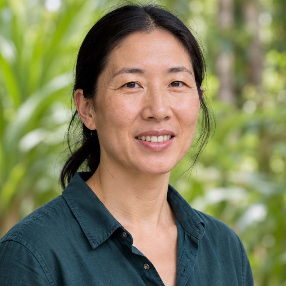 Team member in a dark teal shirt with black hair tied back
