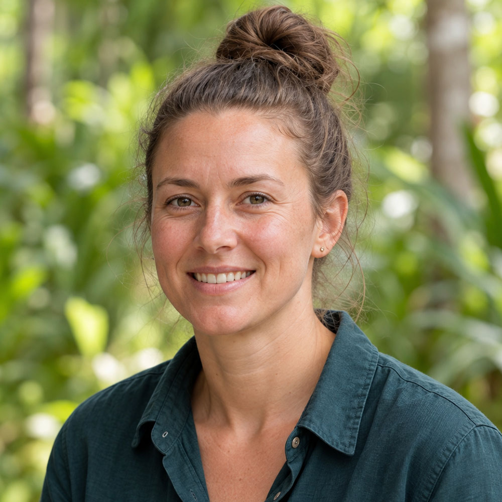 Team member in a dark teal shirt with brown hair in a high bun